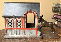 Left side view showing donkey figure pushing against house entry