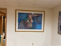 Framed abstract artwork showing a guitar in blue, red, and gray geometric patterns.