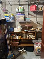 Wide view of garage shelves with a variety of items including cleaning supplies, baskets, and garden tools.