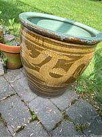 Large outdoor ceramic planter with dragon design, brown and tan colors, green inner rim.