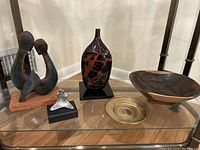 Overview of all items: two couple sculptures, vase, brass tray with Lincoln coin, wooden bowl on pedestal.