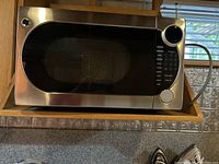 Front view of GE stainless steel convection microwave oven showing door and control panel.