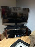 Wide shot showing TV mounted on stand with soundbar below and subwoofer to side