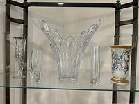 Full view of five vases including crystal, clear glass, and porcelain with horse design.