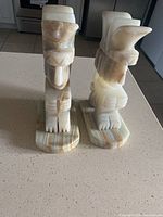 Front and side view of the two carved stone Aztec style bookends showing color, texture, and shape with wear marks visible