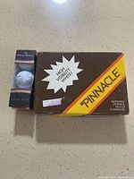 Box of Pinnacle golf balls and Tommy Armour Silver Scot golf ball boxed together showing packaging details