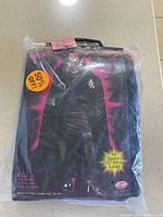 Photo of original packaging showing the cape folded inside a clear plastic bag with a handle. Text on package states 66 inches long and 50% off sticker.