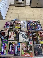Wide view of all Halloween makeup kits and accessories laid out on the kitchen counter showing packaging and quantity