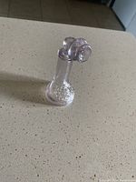 Glass candy container shaped like a vintage phone shown from side angle, missing bottom piece.