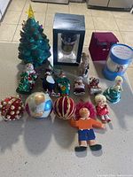 Full view of the lot including ceramic Christmas tree, assorted figurines, ornaments, and candle.