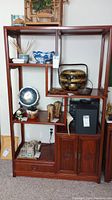 Front view of the tiered display shelf with open shelves holding decorative items
