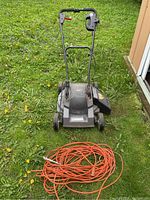 Front view of Craftsman lawnmower on grass next to orange extension cord, showing overall size and condition.