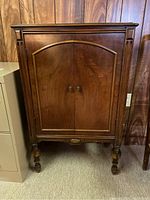 Front view of the Radiola 51 cabinet showing the dark wood finish, arched double doors, and carved column details.