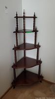 Five tiered wooden corner shelf showing full height and spindle details