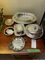 Photo of the entire assortment of silver plated serveware on wooden surface