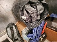 Camping gear packed and packed items including tent components and inflatable.