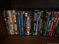First image showing a row of DVD cases with titles like UCLA Soundtrack, White Air, Ghosting of a Smile, The Body of the Lies, The Universe, and Bad Education among others.