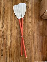 Photo showing two white-bladed paddles with red shafts, 41 inches long each