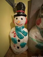 Front view of one snowman blow mold removed from packaging, showing painted features and overall condition.