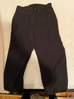 Dark-colored women’s pants laid flat showing front and belt loops.