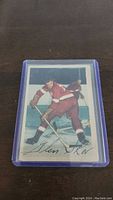 Front of Glen Skov hockey card in protective sleeve showing player in action with printed signature.