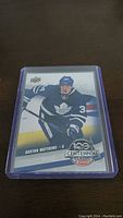Front side of Auston Matthews rookie card showing player in Toronto Maple Leafs uniform with team colors and card branding.