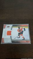 Front of Wayne Simmonds hockey card showing player image and embedded orange jersey patch.