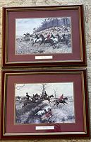 Photo of both framed hunting prints laid flat showing detailed scenes and framing style