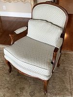 Front angled view showing seat cushion, arm rests, wood carving detail