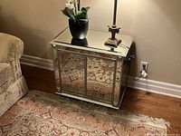 Mirrored chest closed, showing reflective beveled glass panels on all visible surfaces.