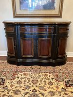 Front view of curved wooden buffet showing three drawers above four doors