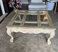 Front corner and top angle view showing carved legs and glass panel inserts