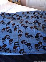 Blue silk and wool scarf spread out showing repeated skull pattern