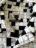 Close-up photo of the pajama fabric and label The Cat's Pajamas, size XS.