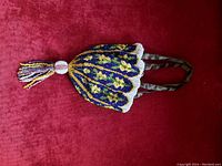 Front view of the beaded purse showing floral beadwork and beaded tassel