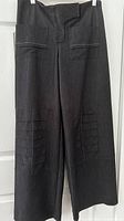 Dark grey baggy pants front view with patch pockets and Velcro waist flap