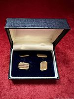 Pair of cufflinks displayed in black leatherette box with velvet insert