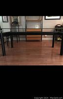 Full view of the Le Corbusier LC6 table with custom black frame and glass top.