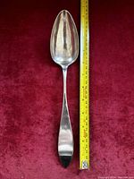 Full view of the old sterling trifle spoon with tape measure showing length about 15cm