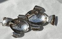 Top view of two fish-shaped sterling silver nut dishes nested together showing scale and fin details.