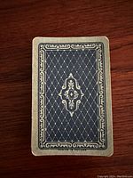 Back of one playing card showing the intricate blue and cream patterned design with 'Printed in Holland' text.
