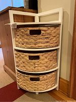 White corner shelf with three wicker drawers from front angle