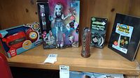 Shelf display showing the Mattel Monster High Frankie Stein doll in packaging, the carved wooden cup, and the red toy vehicle.