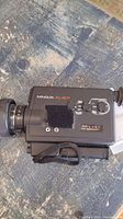 Top side view of Minolta XL401 vintage movie camera showing model label, control dials, and wrist strap.