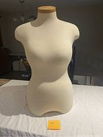 Front view of the half body female mannequin torso showing fabric covering and wooden top