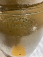 Close-up of maker's mark 'BELLEVILLE STONEWARE' stamped on the crock surface.