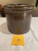 Front view of small, 1 gallon antique open crock, brown glazed stoneware with maker's mark 'WE Welding Brantford Ont'. Shows wear and small chips around rim.