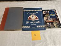 Three hardcover books on stoneware pottery arranged side by side on a table.