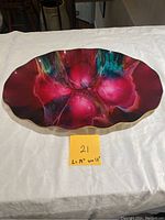 Top view of decorative art glass platter showing the vibrant multicolor abstract design and scalloped edges.