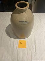 Front view showing 'ROBERTSON BROS WHOLESALE CROCKERY KINGSTON' marking on the stoneware crock, highlighting text and condition.